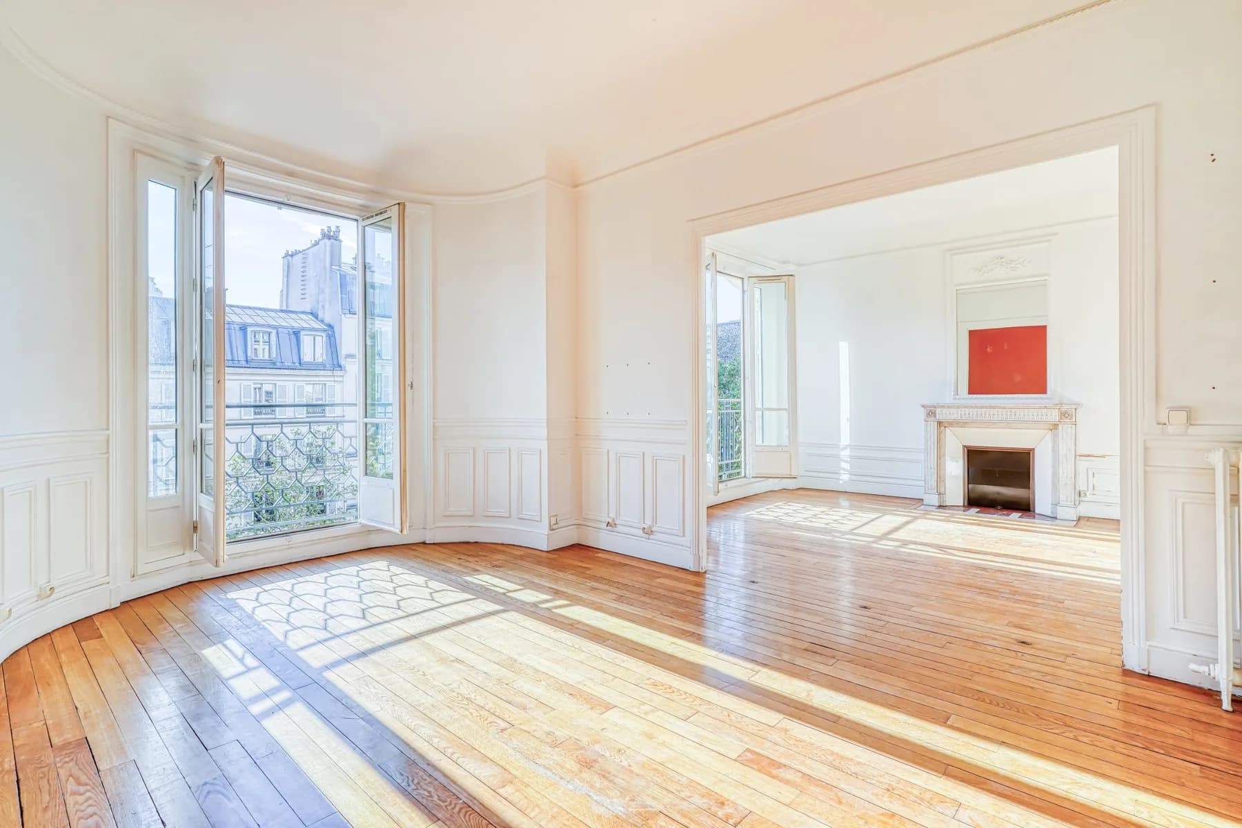 Salle à manger en rotonde, parquet ancien, boiseries et portes-fenêtres sur balcon