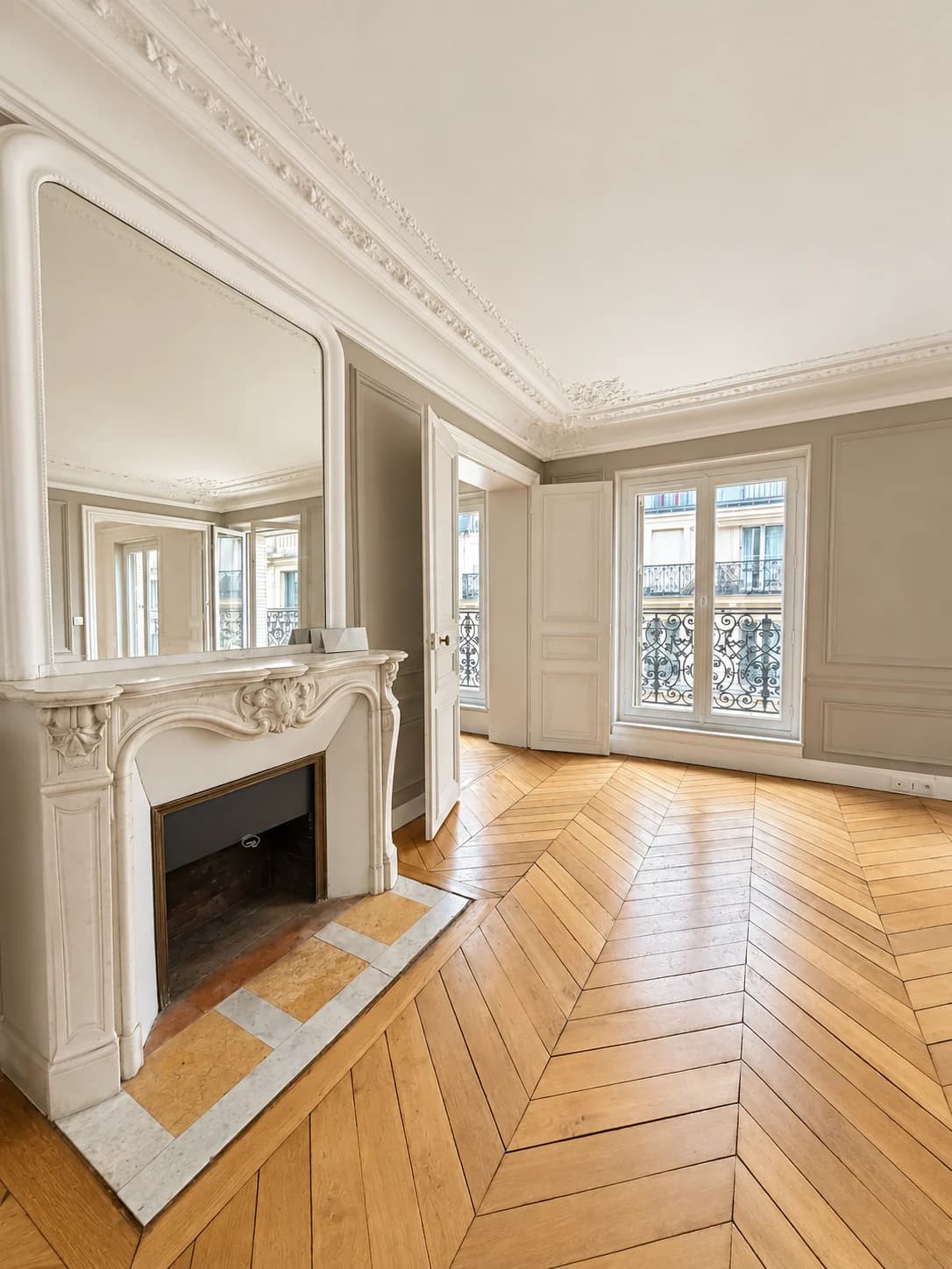 Salon avec cheminée en marbre, grand miroir et portes-fenêtres