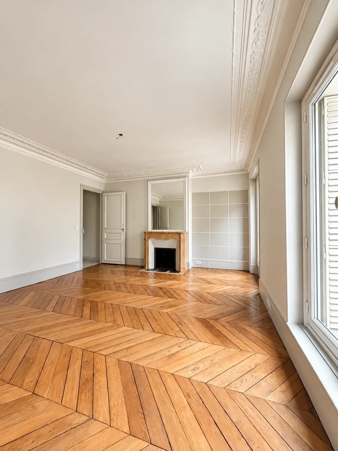 Pièce lumineuse avec cheminée en marbre et parquet point de Hongrie
