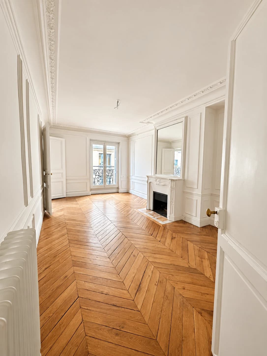 Chambre avec cheminée en marbre blanc, miroir et porte-fenêtre